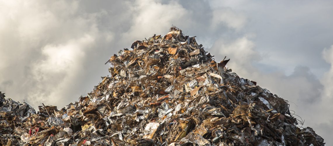 heap of scrap iron against dramatic cloudy sky